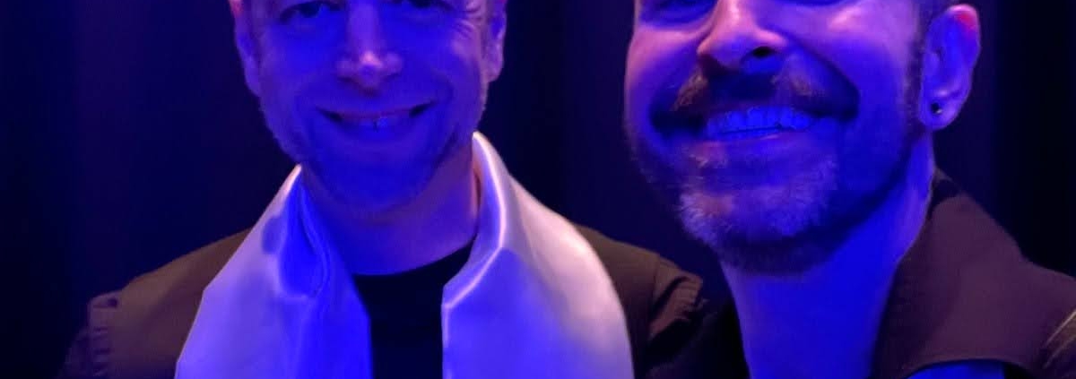 Two men standing in blue light