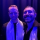 Two men standing in blue light